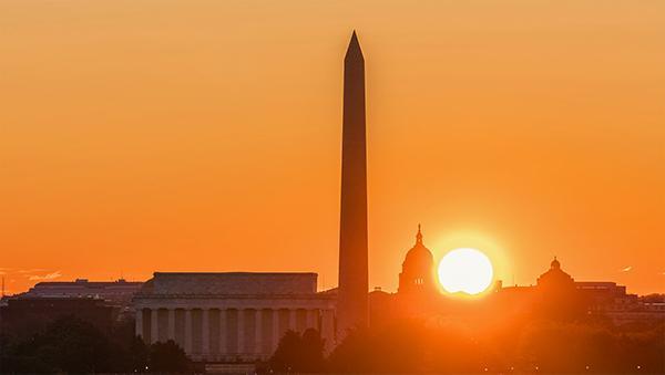 The sun sets over the Washington Memorial in Washington, D.C.